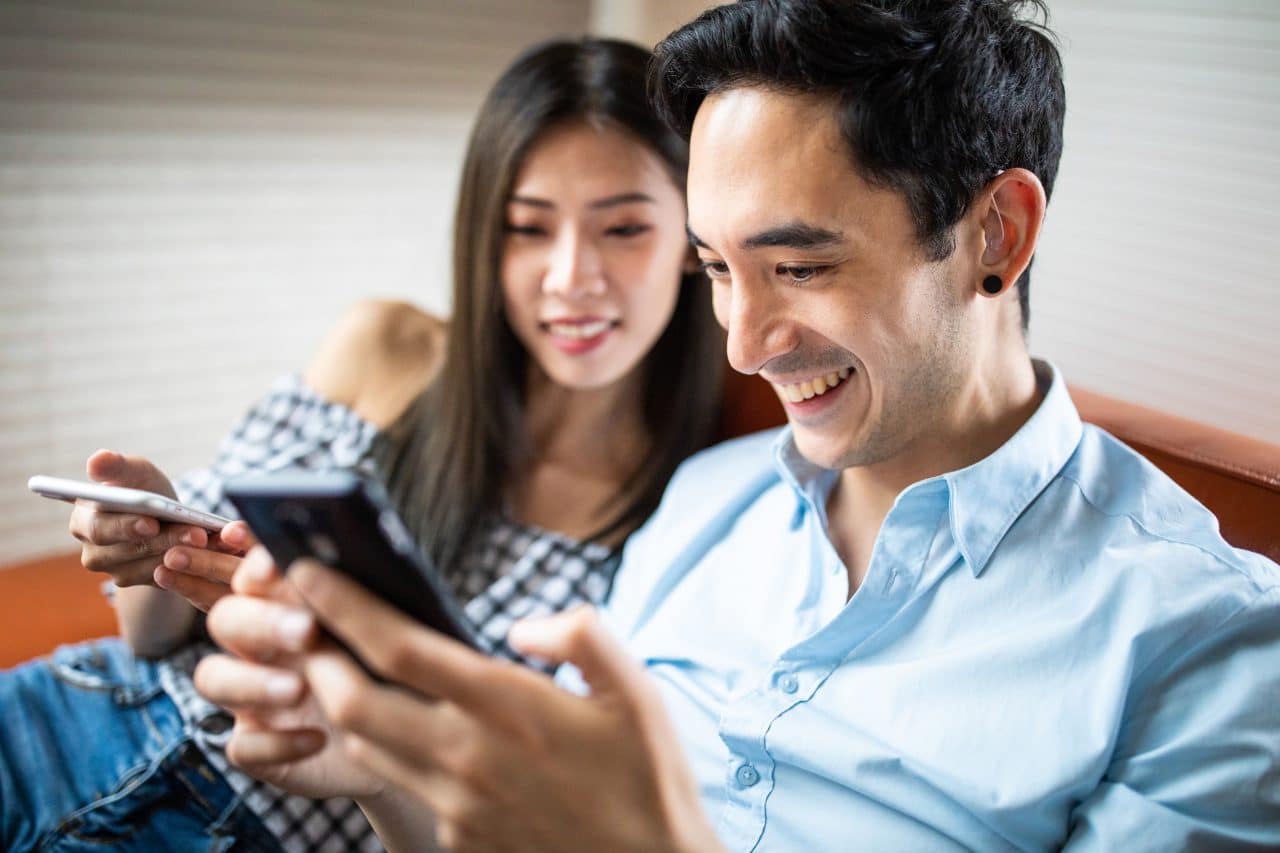 Couple relaxing at home, man wearing hearing aid.