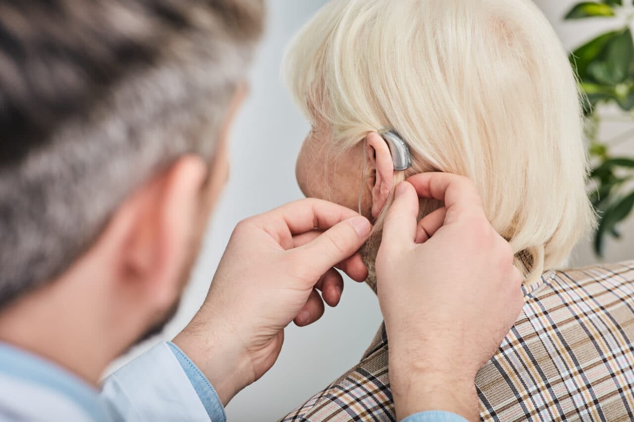 Woman getting fitted for a hearing aid.