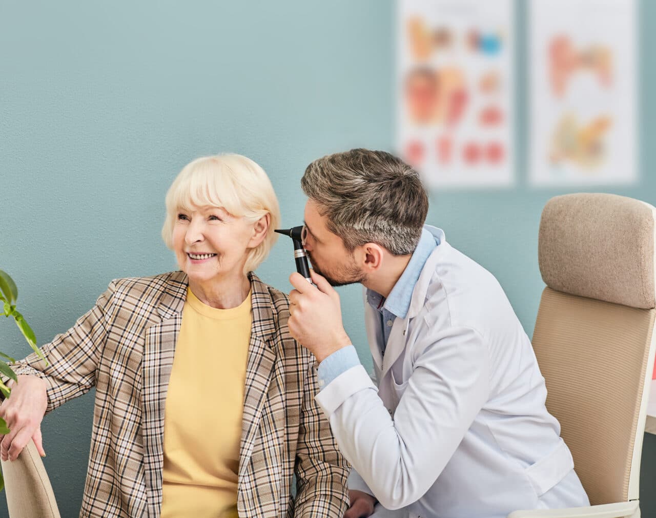 Happy older woman getting her hearing checked.