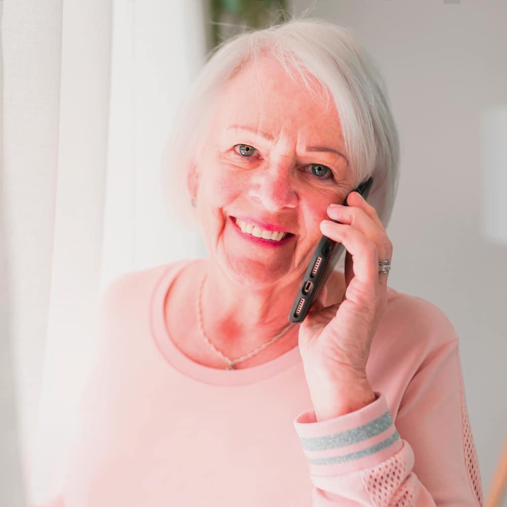 a woman holds her phone to her ear