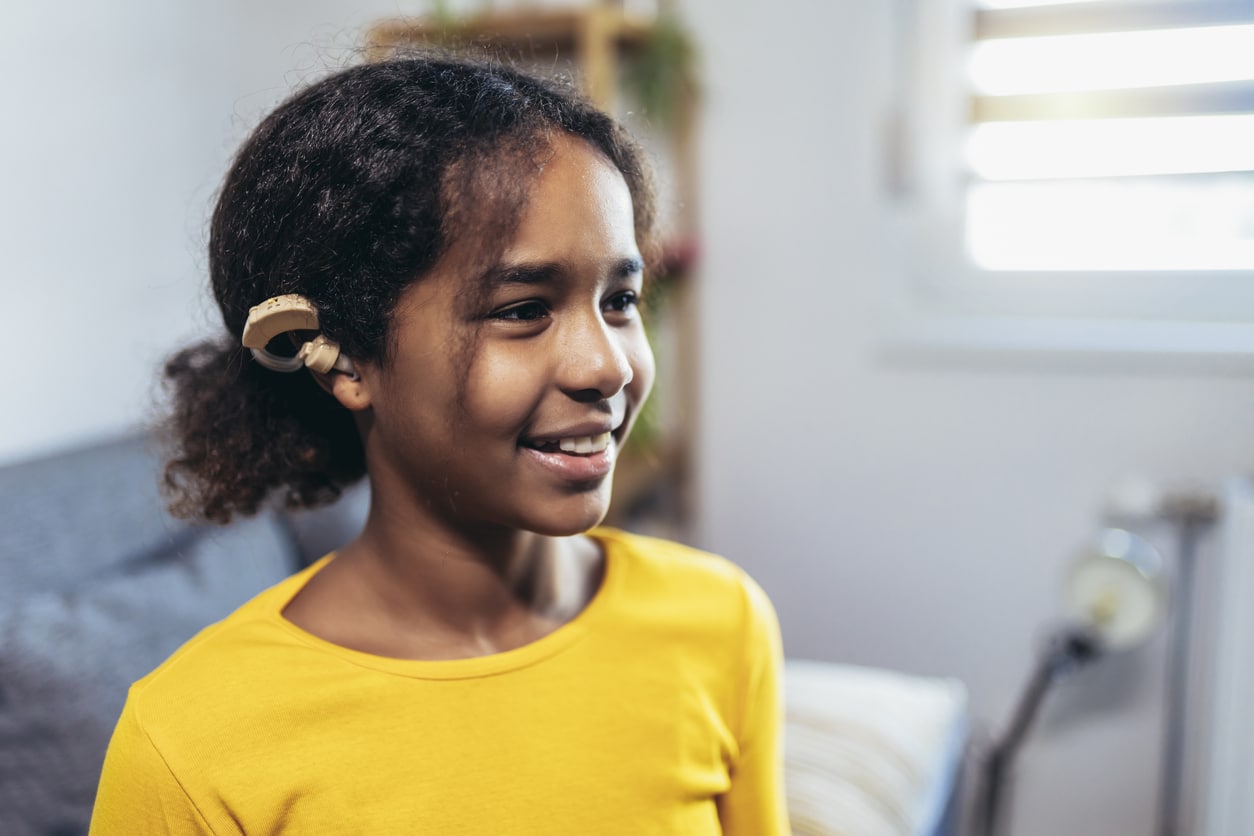 Young girl wearing a hearing aid.
