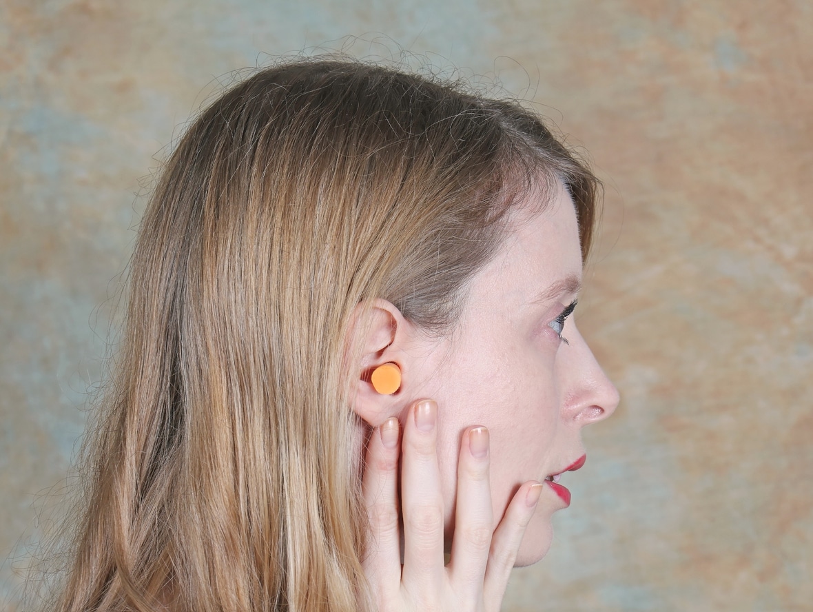 Side view of a woman wearing earplugs.