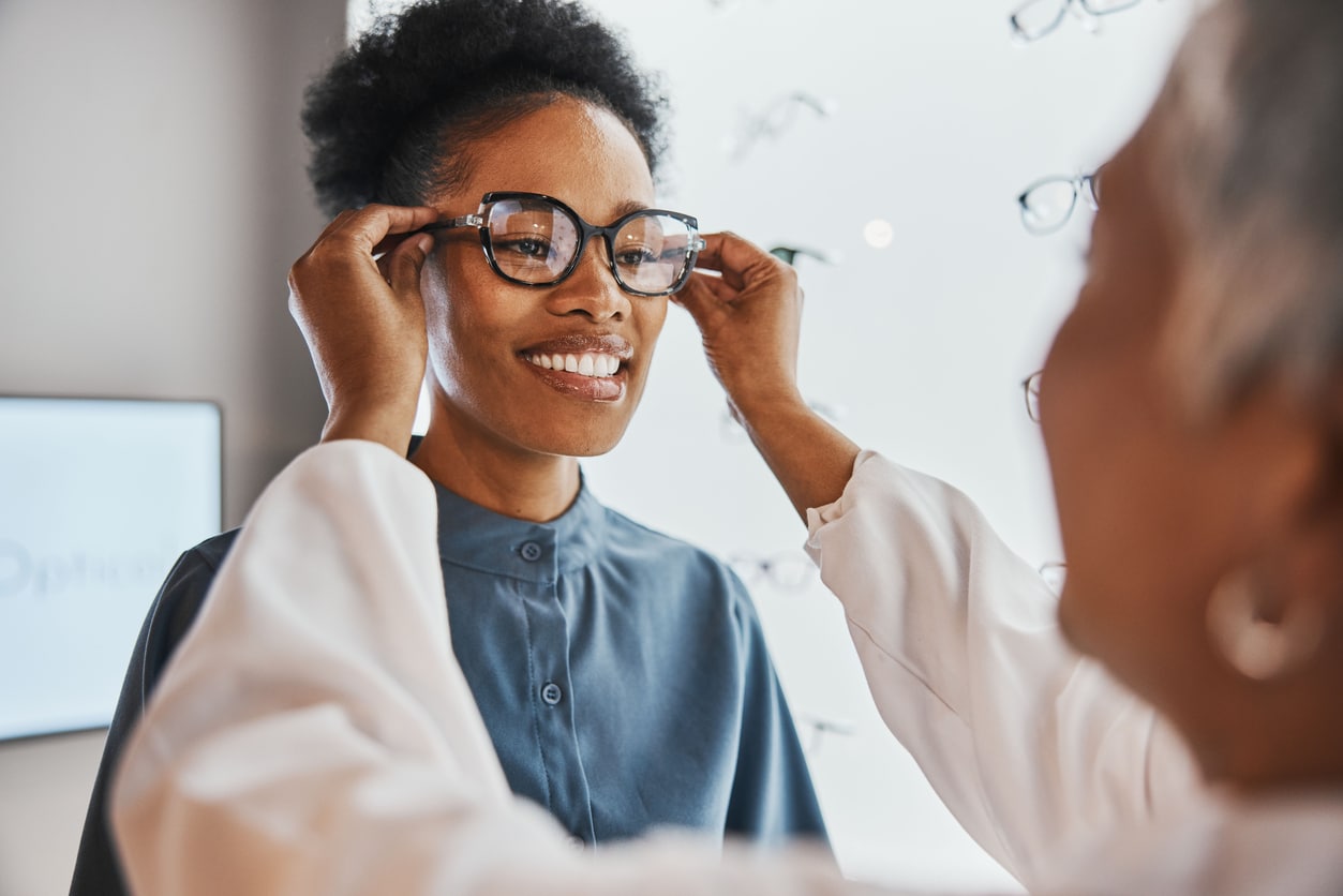 Woman trying on new glasses at the eye doctor.