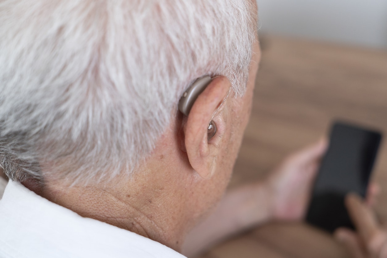 Close up of a senior man wearing a hearing aid.