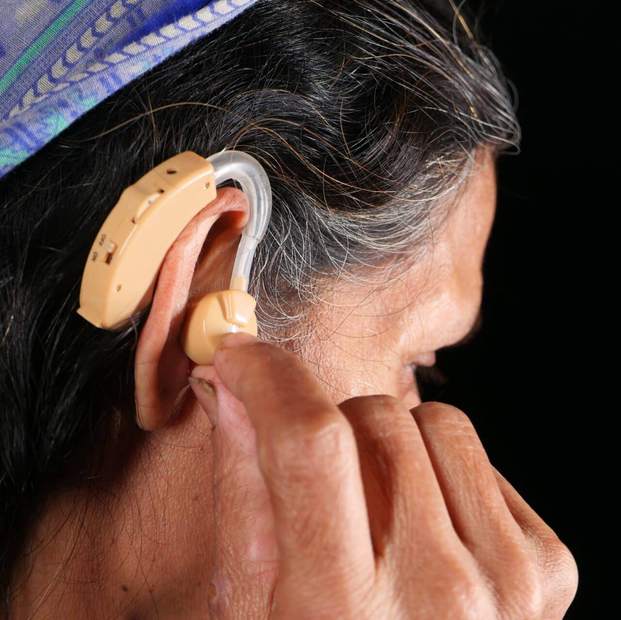 Person adjusting their hearing aid.